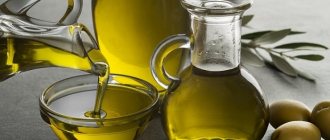 olive oil in a decanter and bowl, three fresh olives