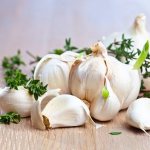 garlic cloves in peels with herbs